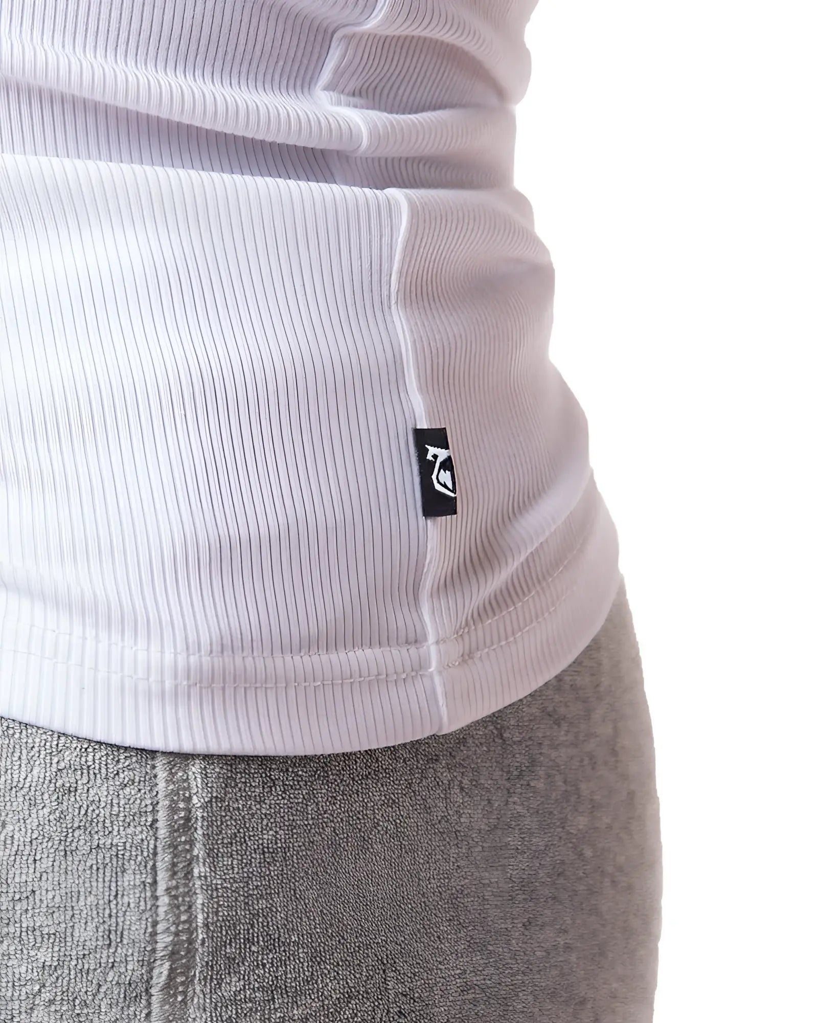 White ribbed knit pig rib tank top with small black logo tag at the hem