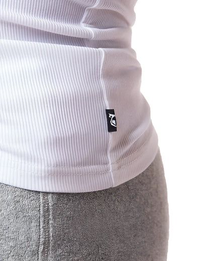 White ribbed knit pig rib tank top with small black logo tag at the hem