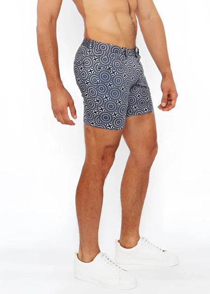 Printed stretch knit short swim trunks in blue and white geometric patterned fabric designed for comfort and style
