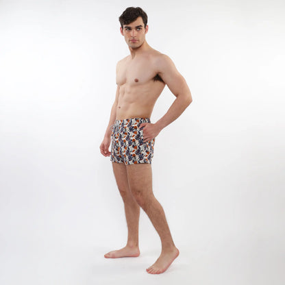 Printed swim short with mesh lining featuring navy orange and white tropical leaf pattern on light fabric