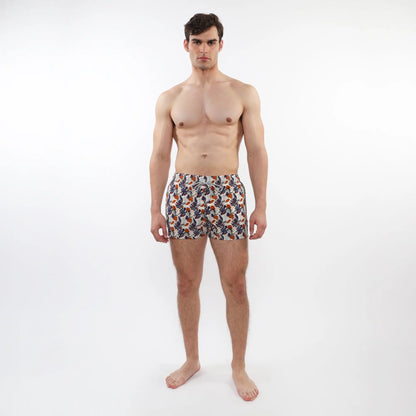 Men’s printed swim short with mesh lining in orange navy blue and white tropical leaf and fruit pattern on light fabric