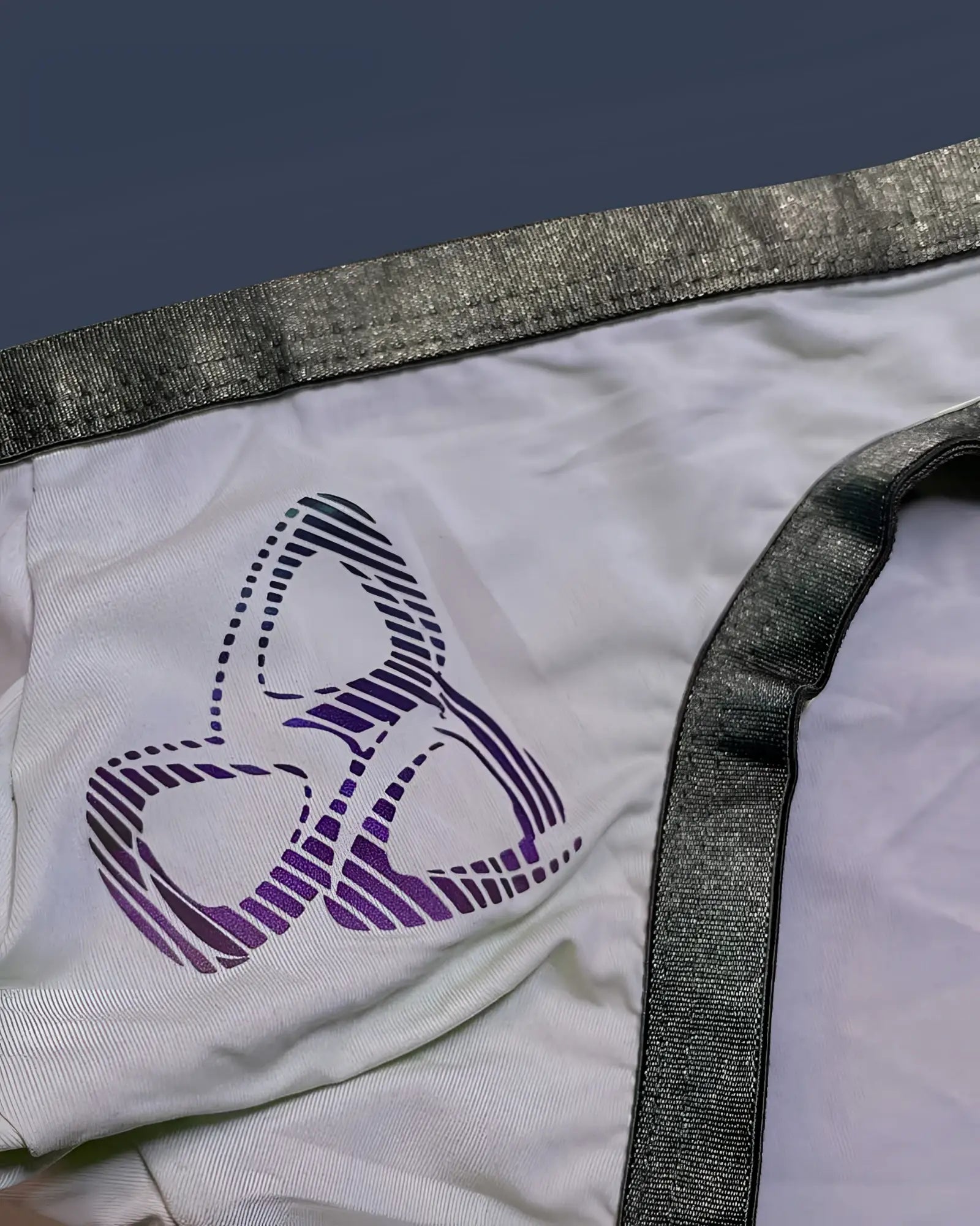 White fabric bare bikini underwear lilac with purple black striped abstract logo and shiny gray elastic waistband trim