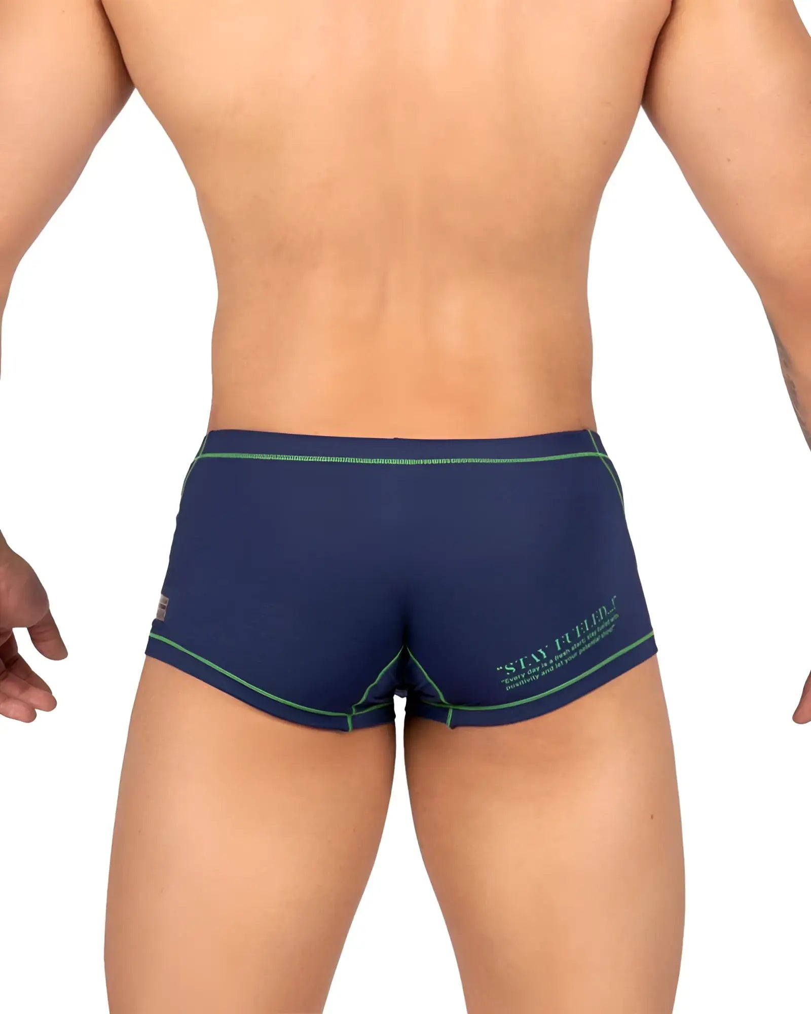 Back view of private structure navy blue swim trunks with green trim and stay firm logo for active beachwear