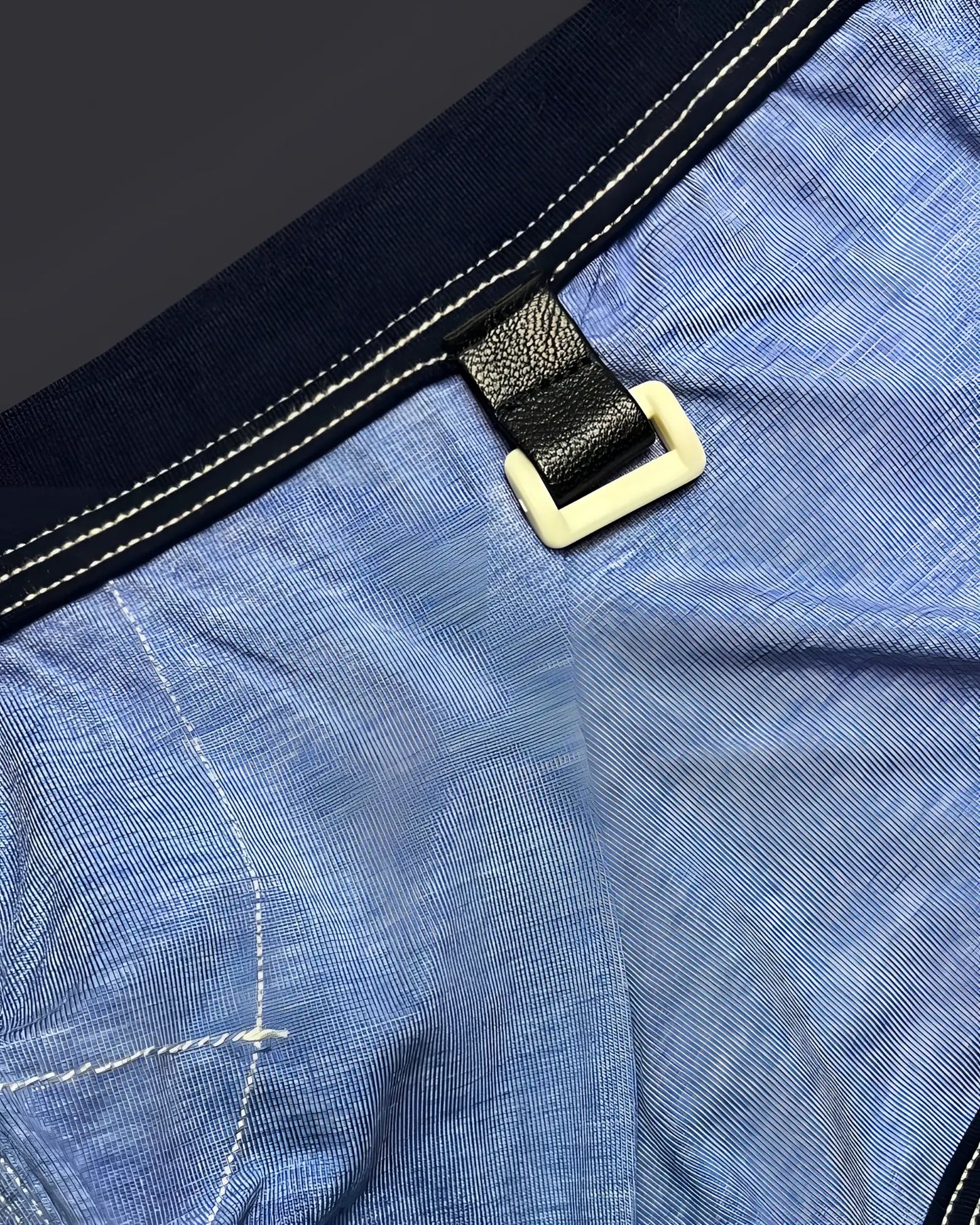 Private structure lcut4359 barn boy low rise trunk in denim with black leather strap and cream plastic buckle on blue fabric