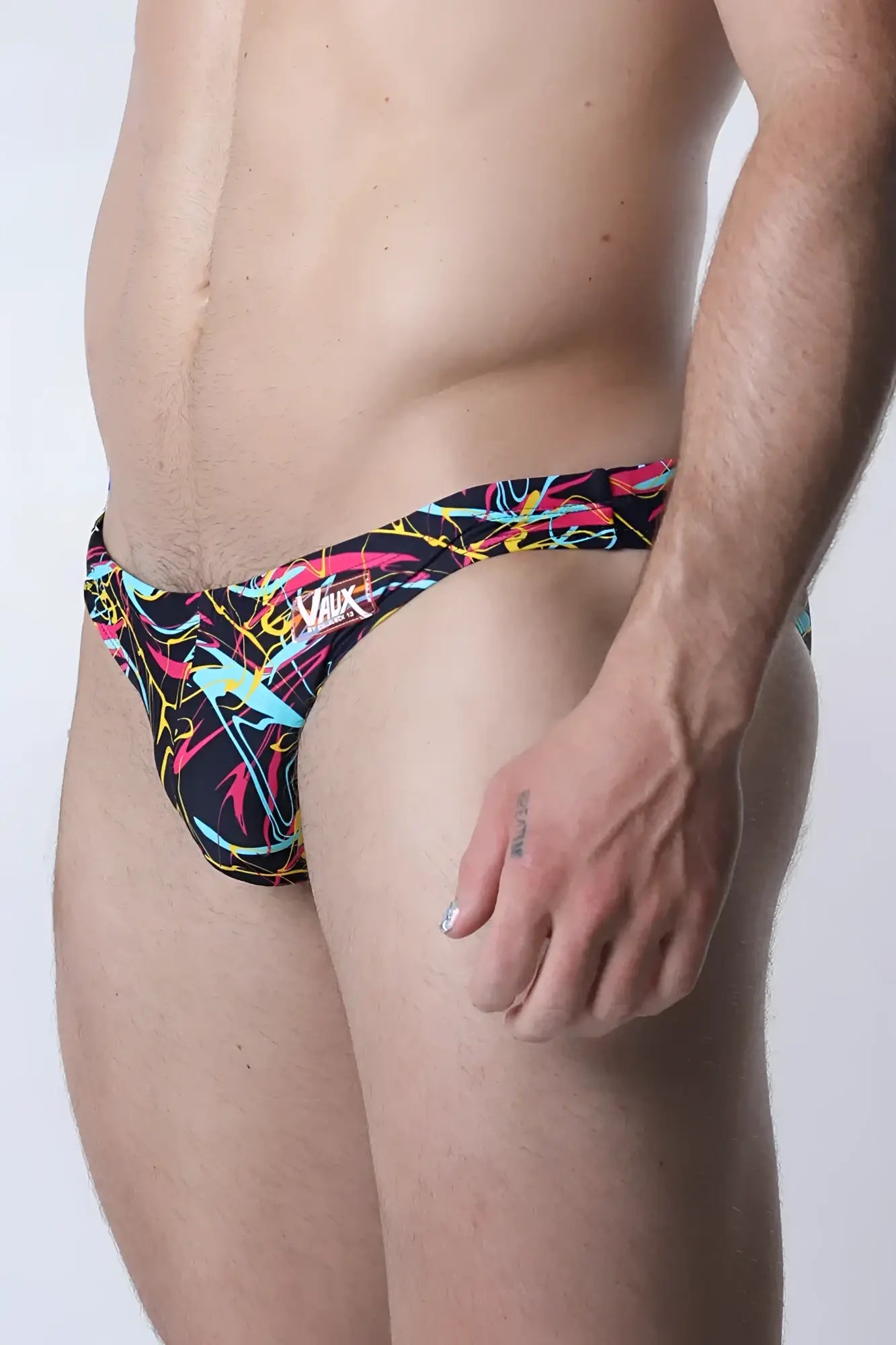 Vaux pulse swim brief men’s trunks with bold neon pink yellow cyan abstract lines on black fabric for swimming