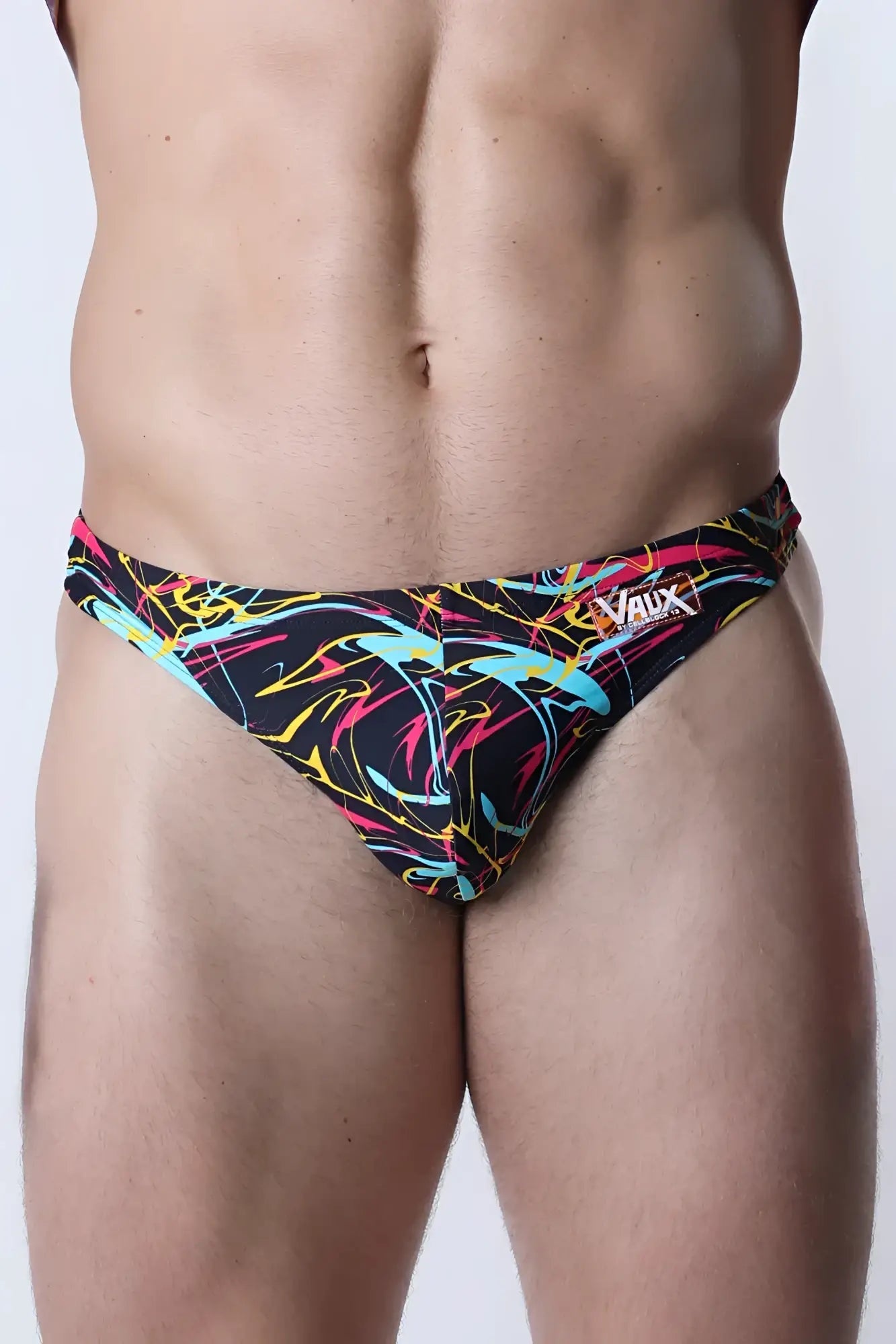 Vaux pulse swim thong in neon pink yellow and cyan abstract pattern on black fabric for men