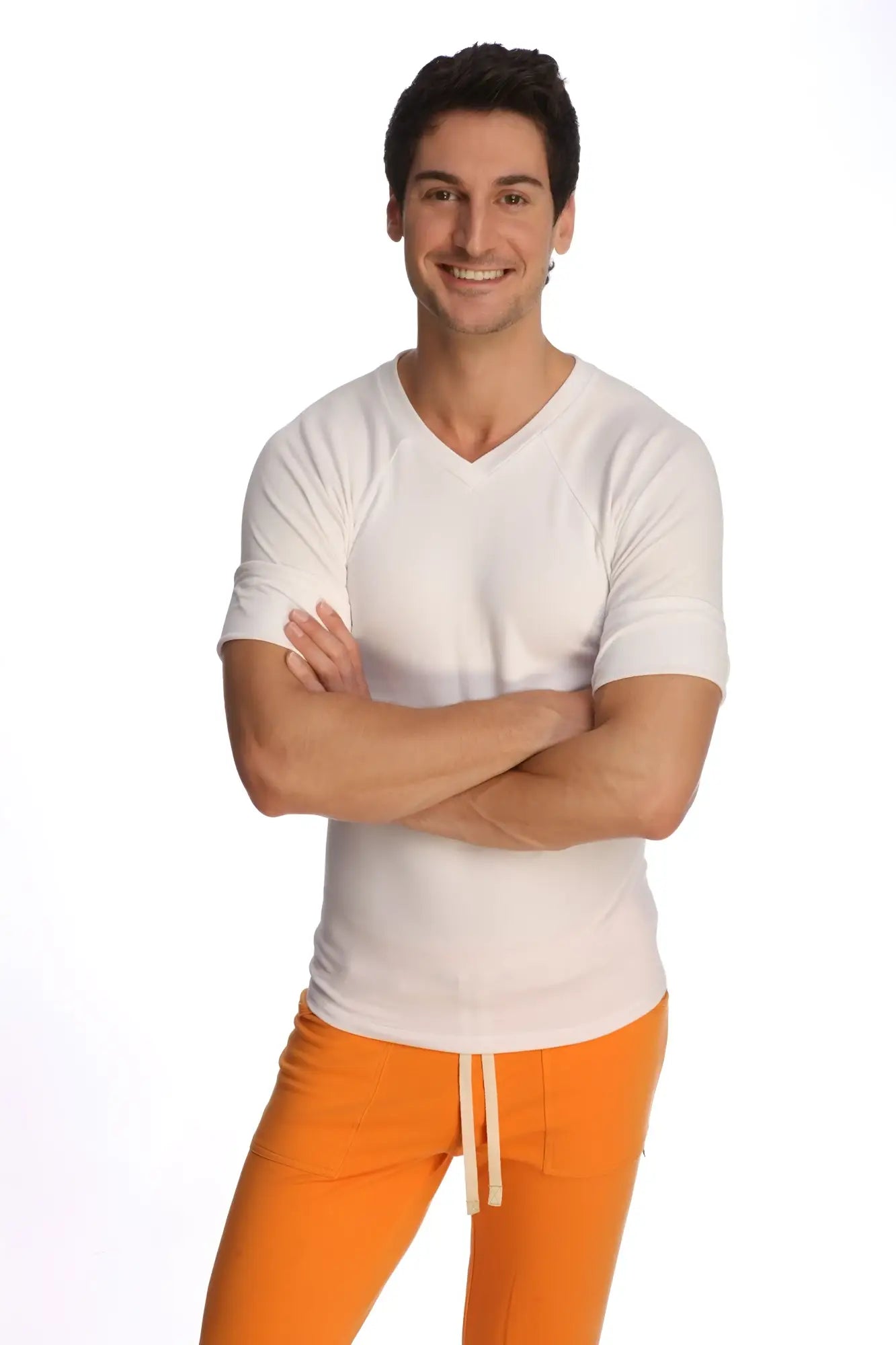 A man wearing a white raglan virtual crew neck v-neck short-sleeved shirt and bright orange drawstring pants
