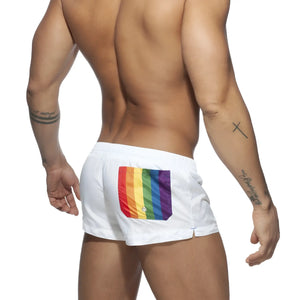 Back side of white rainbow swim short with vibrant rainbow flag patch on swim trunks back pocket