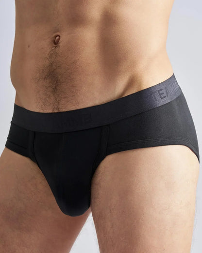 Black men’s briefs with a dark gray elastic waistband featuring the subtle team logo in the reign brief design