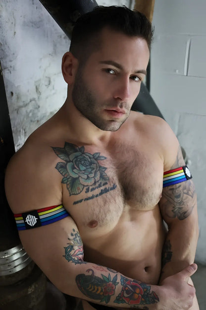 Retro remix armband featuring a rainbow-striped band with a black patch and white emblem on the front