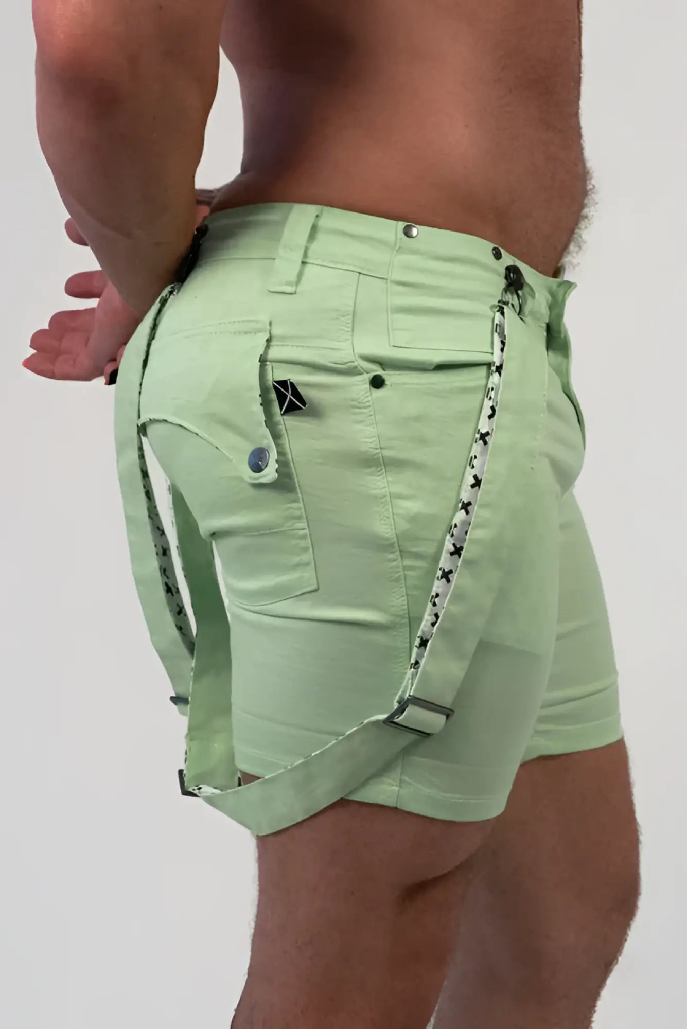 Romey shorts light green with black star patterned straps and a small black logo on the pocket front side