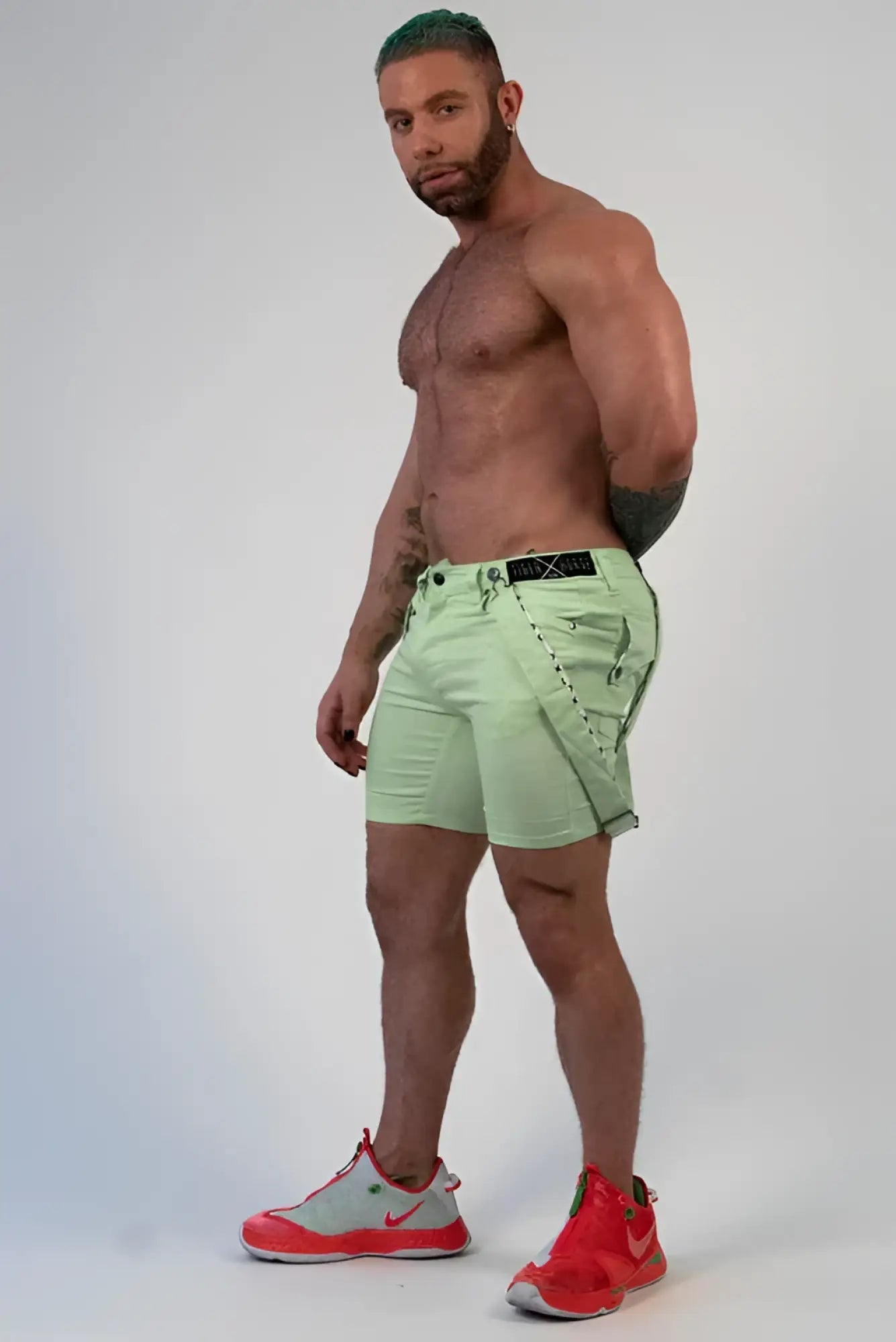 Light green romey shorts with black belt and stitched detailing in durable cargo fabric for casual wear
