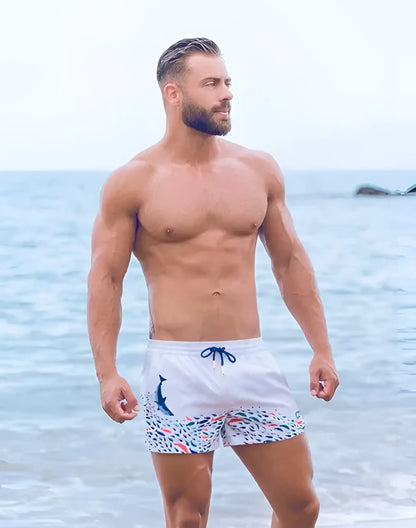 White swim trunks with blue dolphin graphic colorful fish pattern and navy drawstrings s50 seascape print swim short