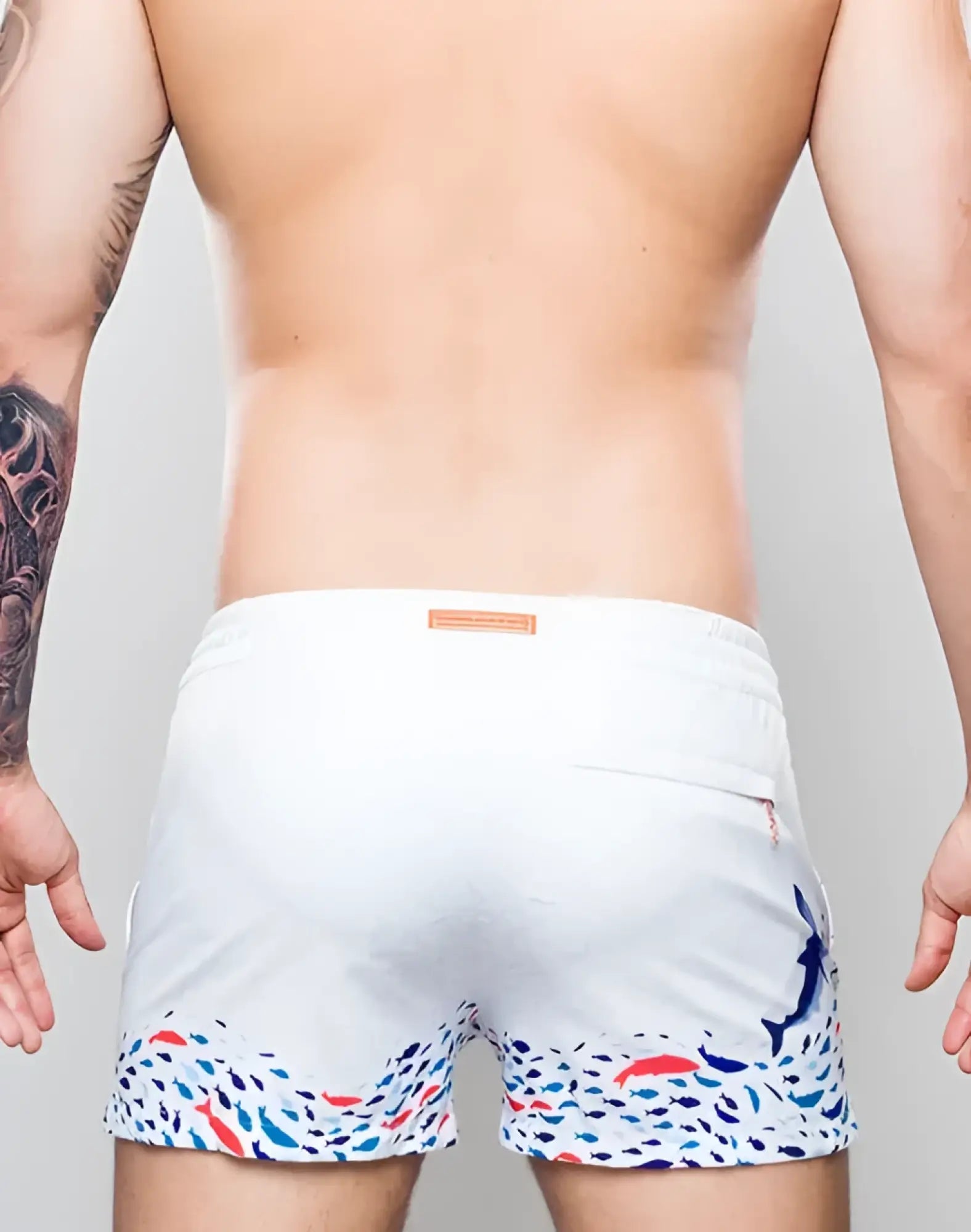 White s50 seascape print swim shorts with colorful fish pattern on hem and side and blue dolphin on right leg