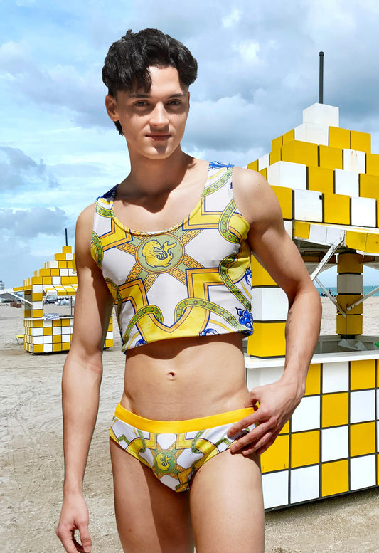 Men's crop tank top in white with yellow and blue geometric patterns worn by a model by Maris Equi.