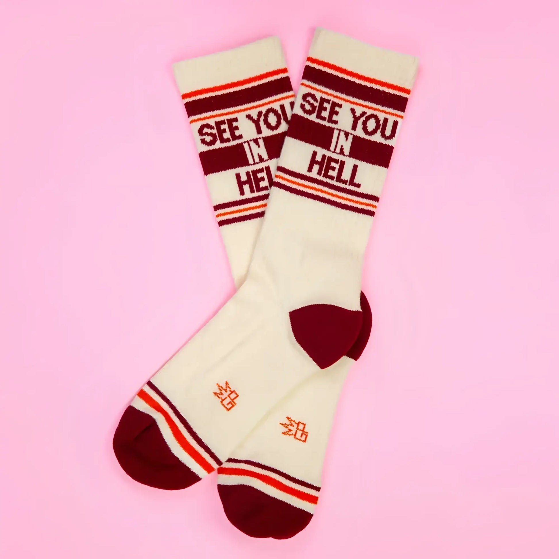Cream-colored crew socks with maroon and orange stripes and bold red see you in hell lettering on the cuff