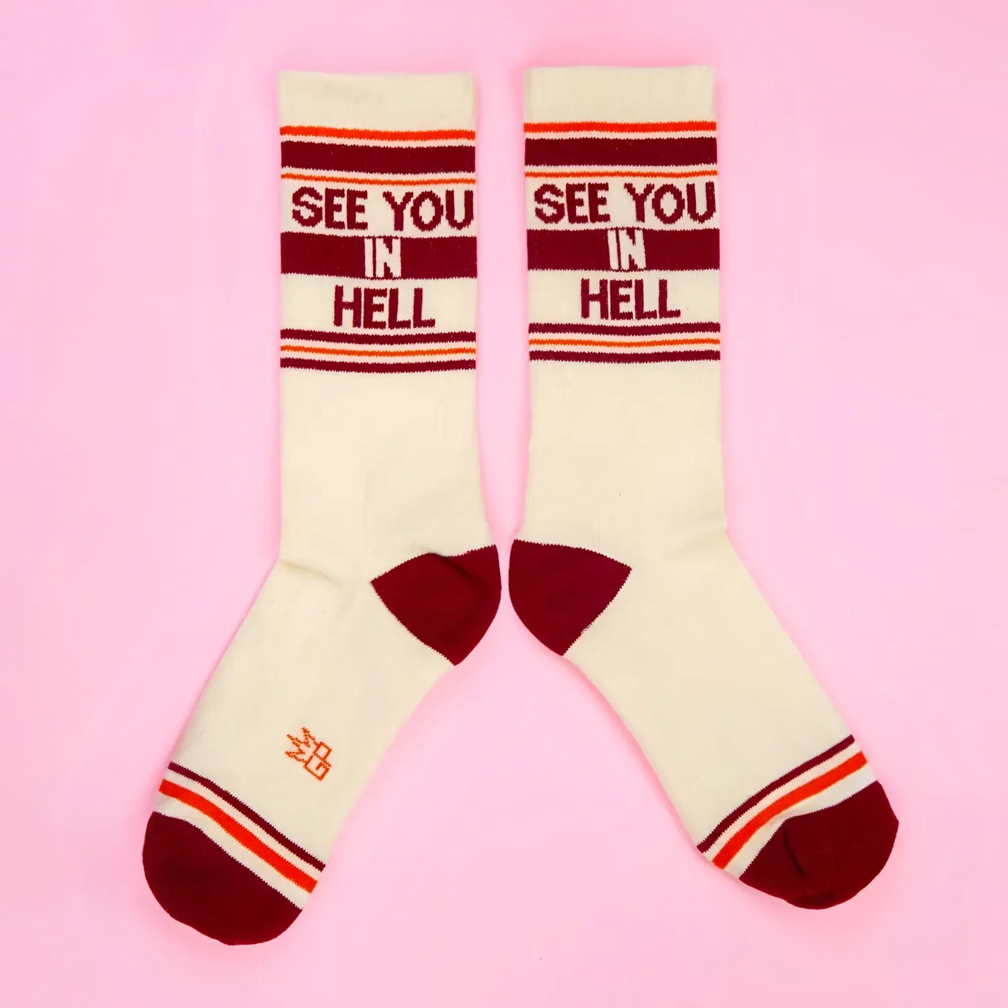 Cream-colored SEE YOU IN HELL crew socks with maroon and orange stripes and bold red lettering across the top