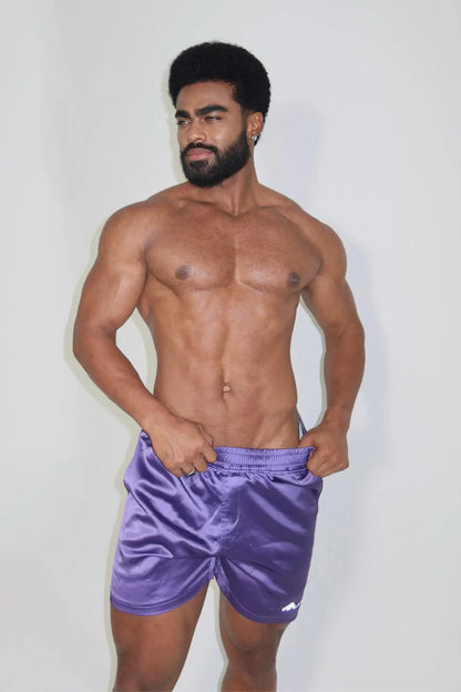 Purple satin shimmerflex active shorts with small white logo on lower right leg for athletic wear