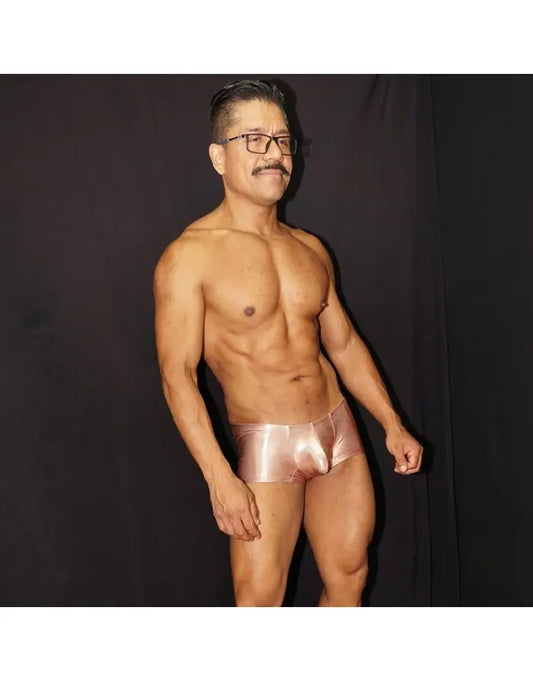 Shiny copper men's boxer underwear by Arroyman featuring a snug fit and smooth material modeled by a man.