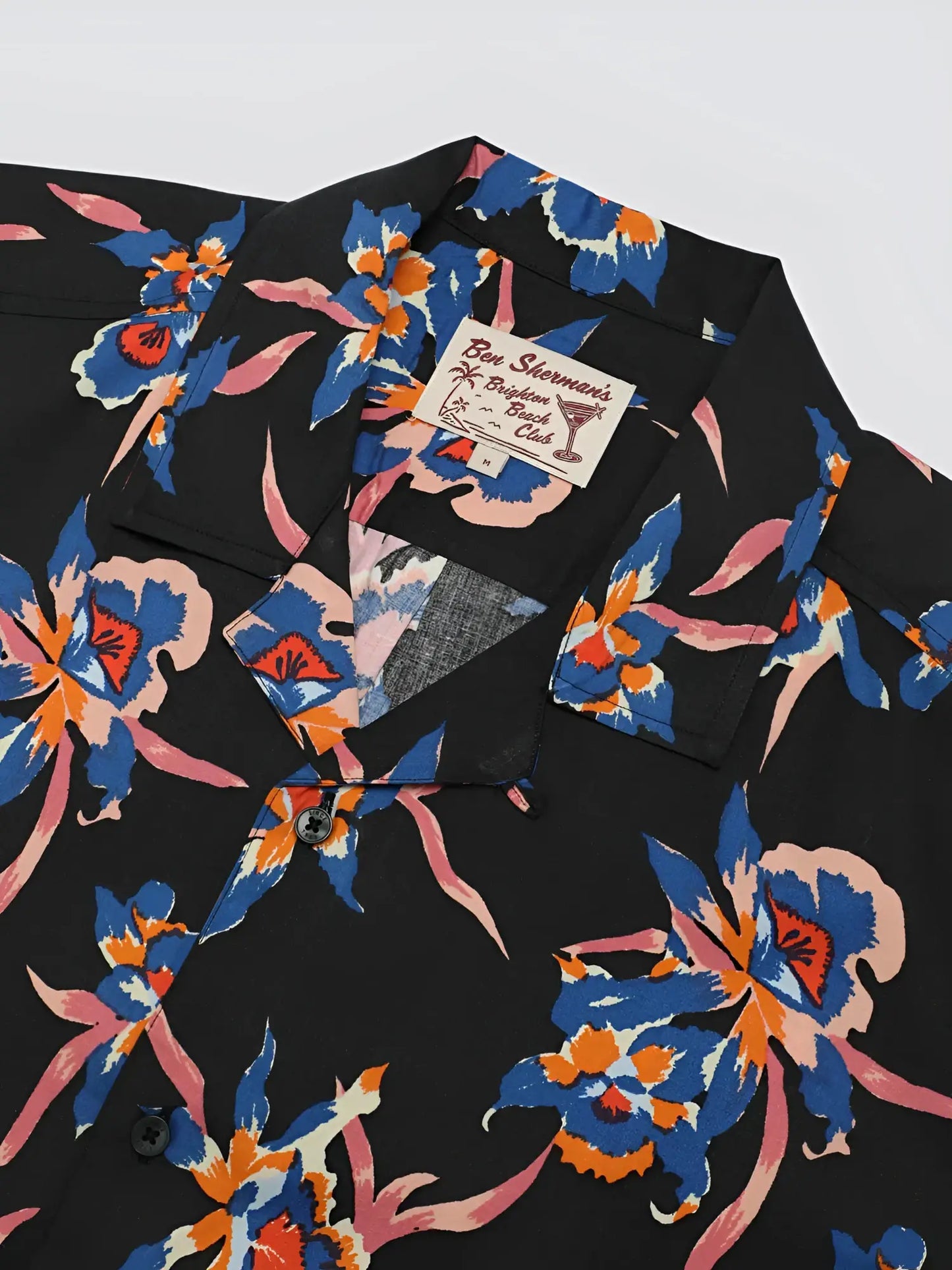 Black button-up shirt with signature botanical print featuring vibrant blue orange and pink floral pattern