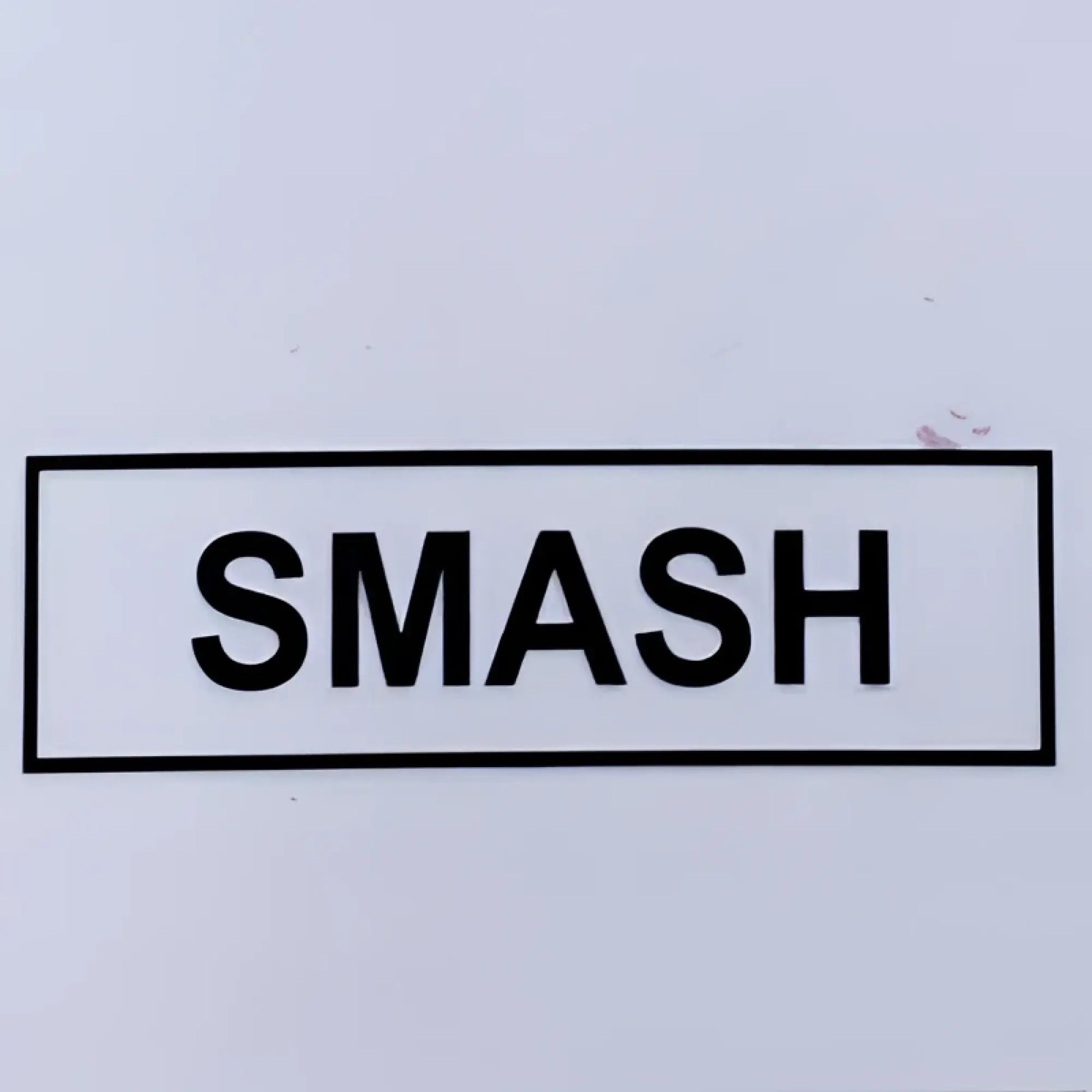 Black smash novelty top featuring a bold uppercase sticker with simple rectangular border design