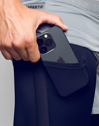 Black iphone with triple-camera system in the back pocket of dark navy spr flex short athletic leggings
