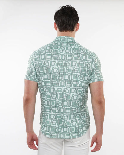 A man wearing a light green short-sleeved squares print open knit shirt with white and dark green geometric patterns