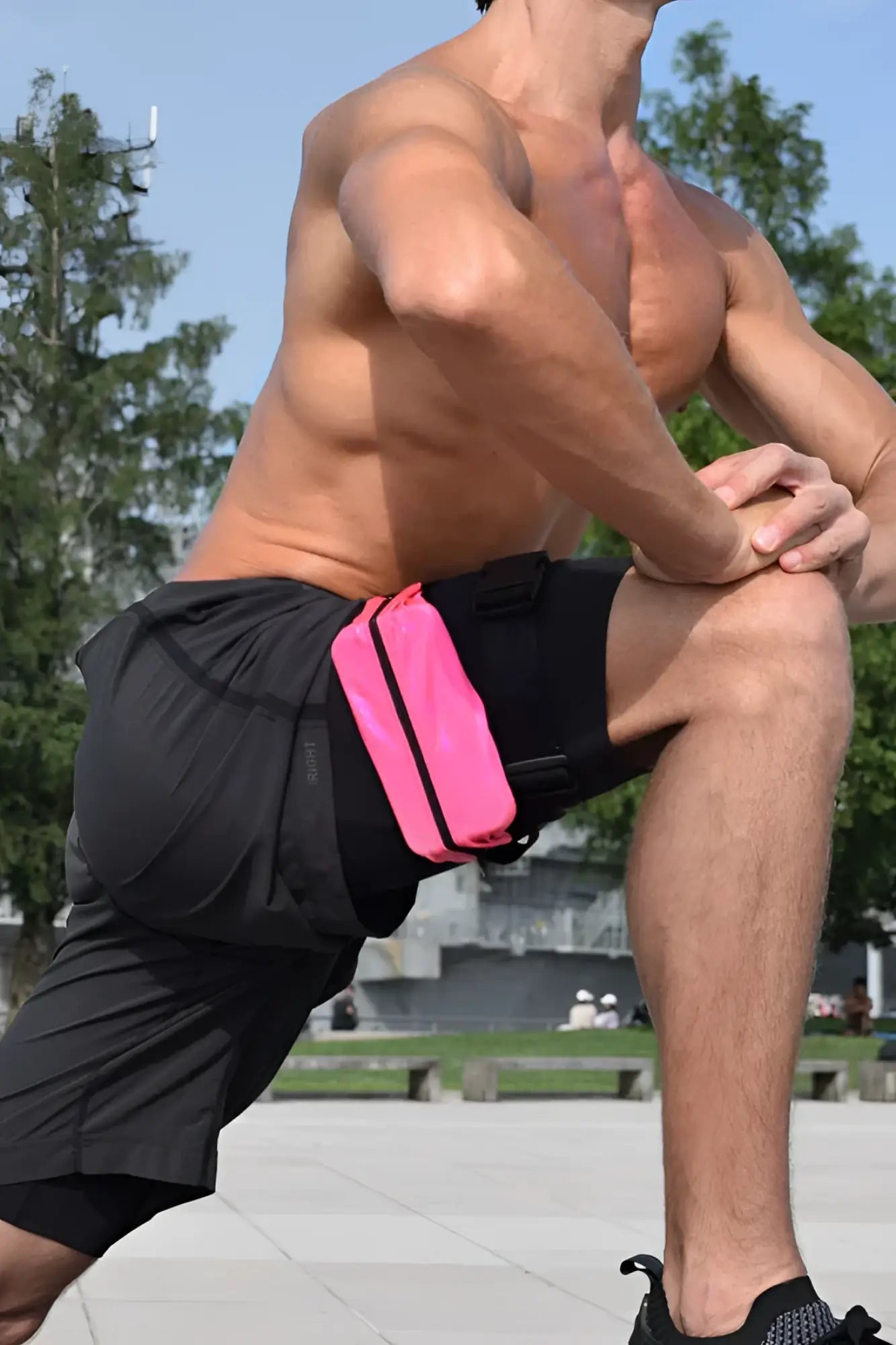 Bright pink ssbag running belt with black trim worn by man in athletic shorts for hands-free running storage