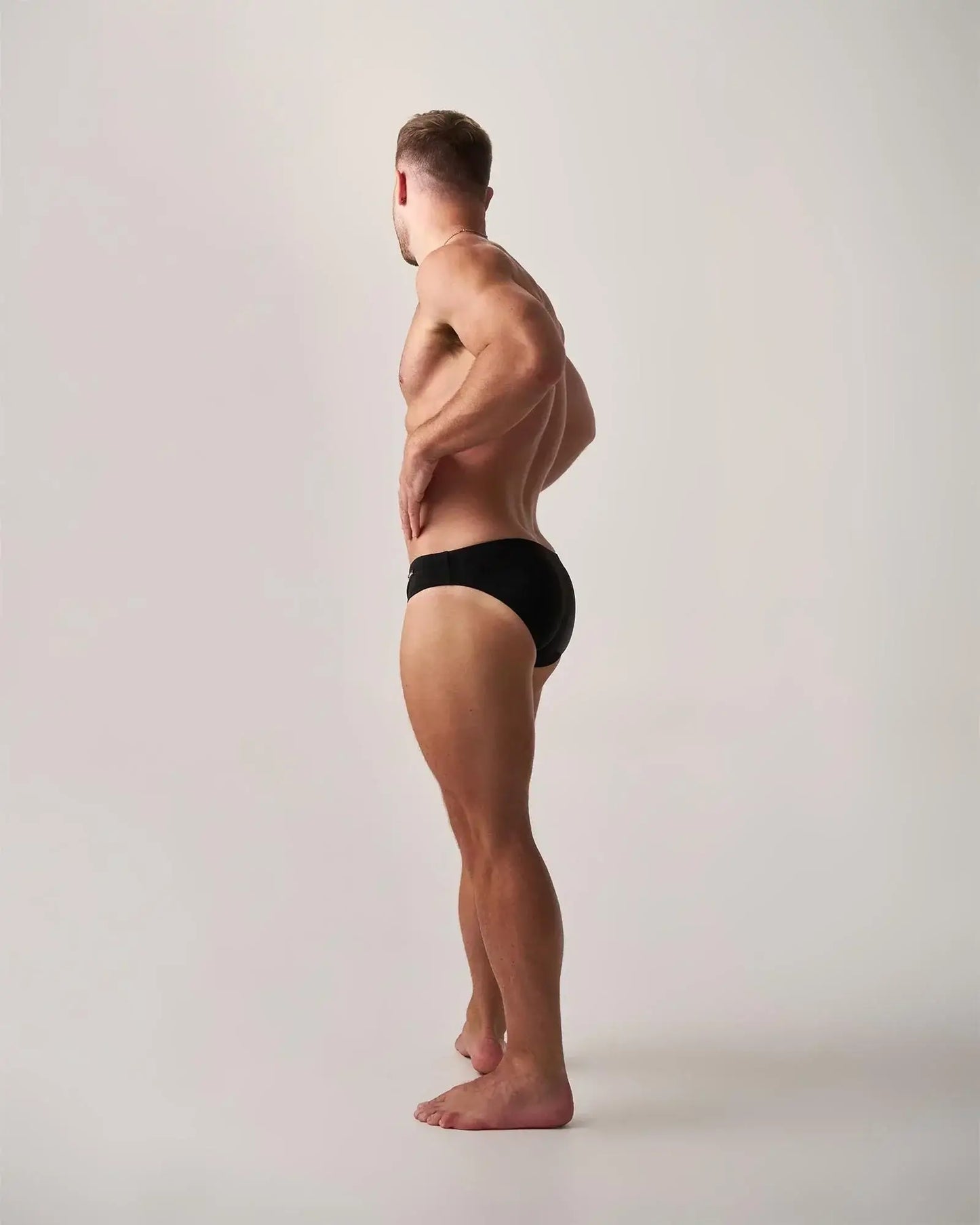 Black statement swim brief showing the back side made of quick-dry fabric ideal for swimming and beachwear