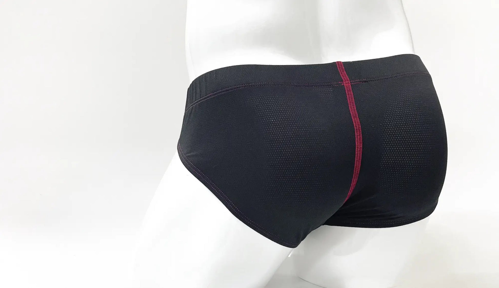 Back view of stitch big boy pouch brief mesh swim trunks in black with a red seam down the center back