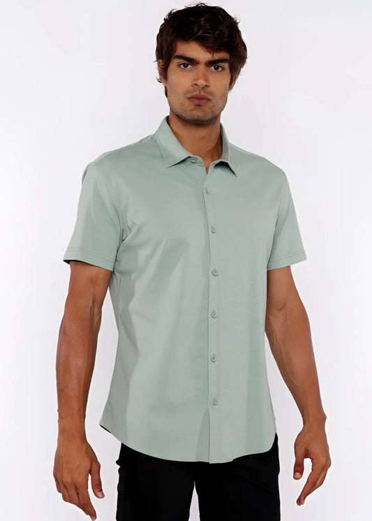 A man wearing a light green stretch knit short-sleeved button-up shirt with a classic collar and pressed fabric