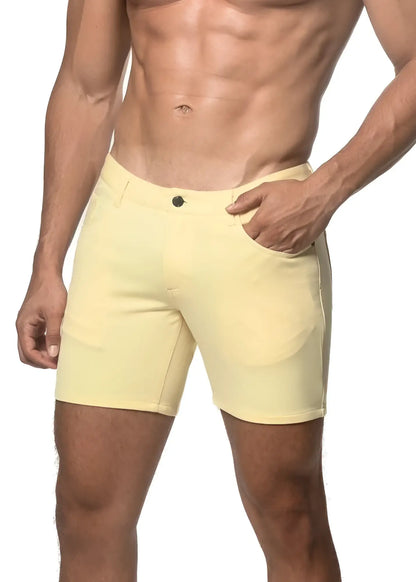 A pair of pale yellow stretch knit shorts with a classic button closure and side pockets in a form-fitting design