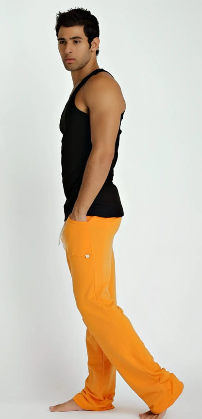 Bright orange loose-fitting pants with small white logo on thigh paired with sustain tank top black