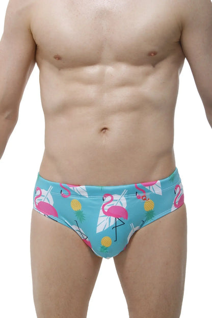 Swim brief pina colada with male cup pad in bright turquoise featuring pink flamingos yellow pineapples and white leaves