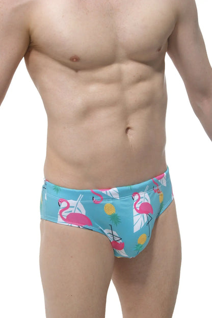 Swim brief pina colada with male cup pad in bright turquoise featuring pink flamingos yellow pineapples and white leaves