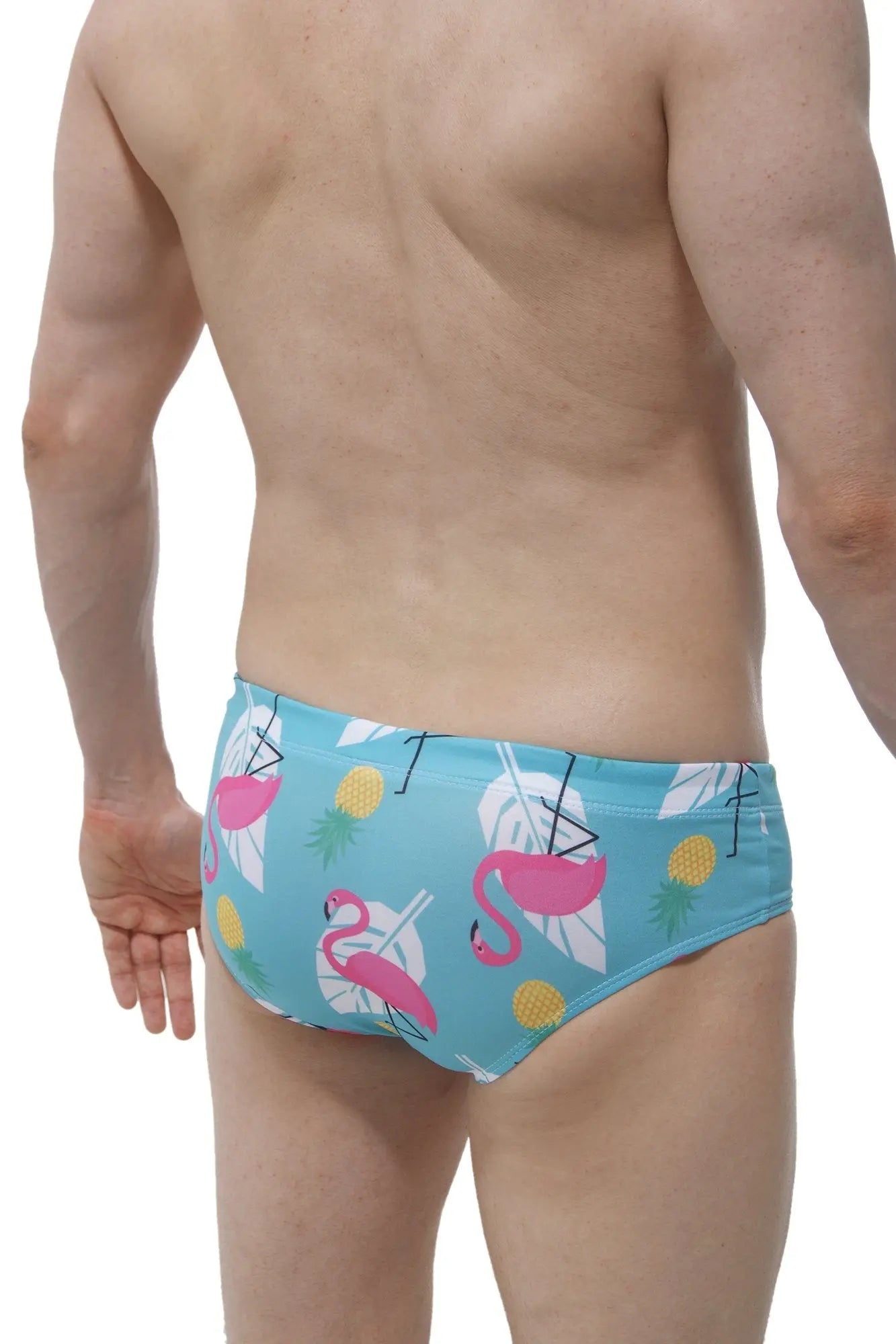 Light blue swim brief pina colada with a male cup pad featuring pink flamingos white tropical leaves and yellow pineapples