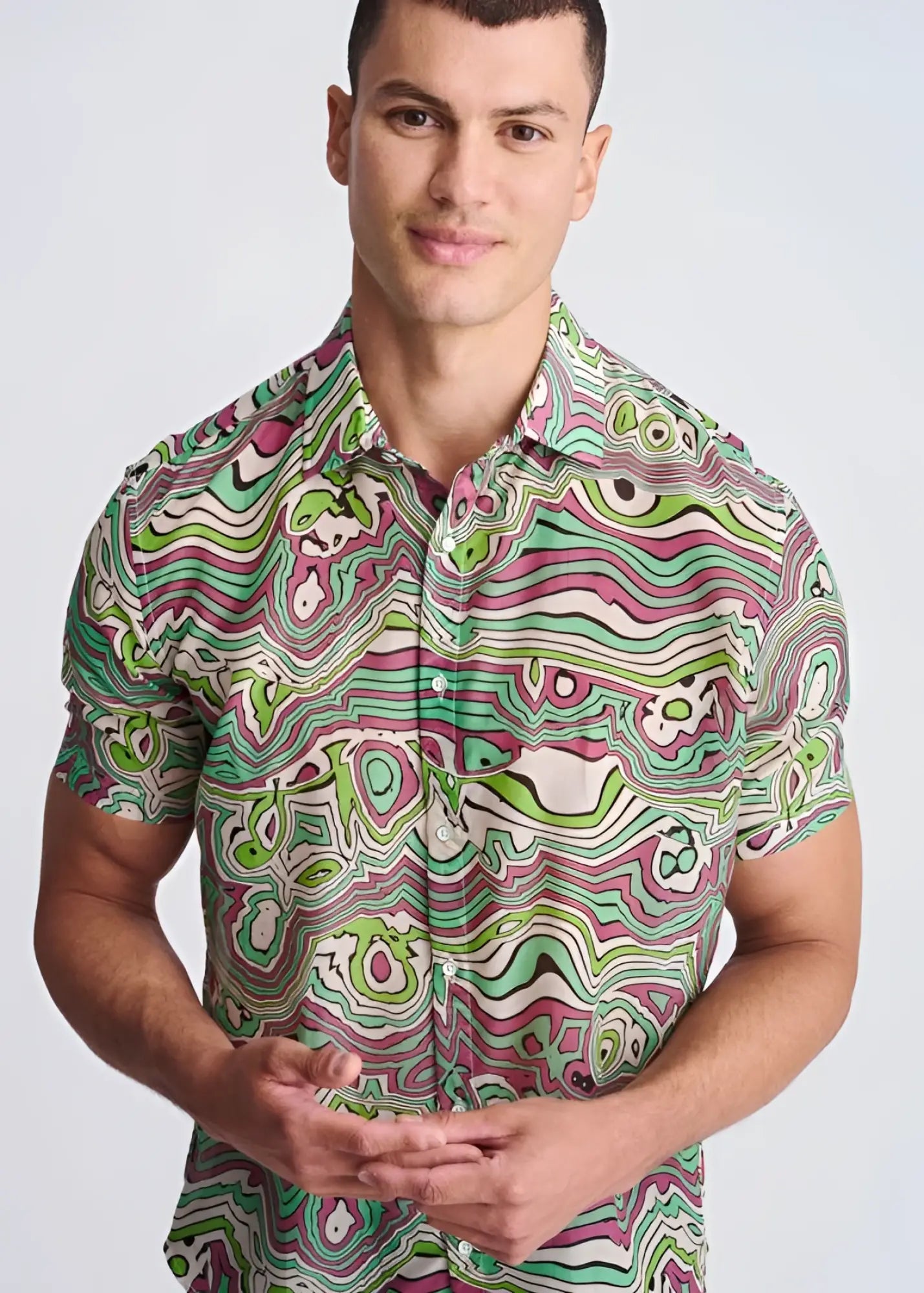 A vibrant short-sleeved lightweight cotton silk shirt with a psychedelic green pink and white swirl pattern