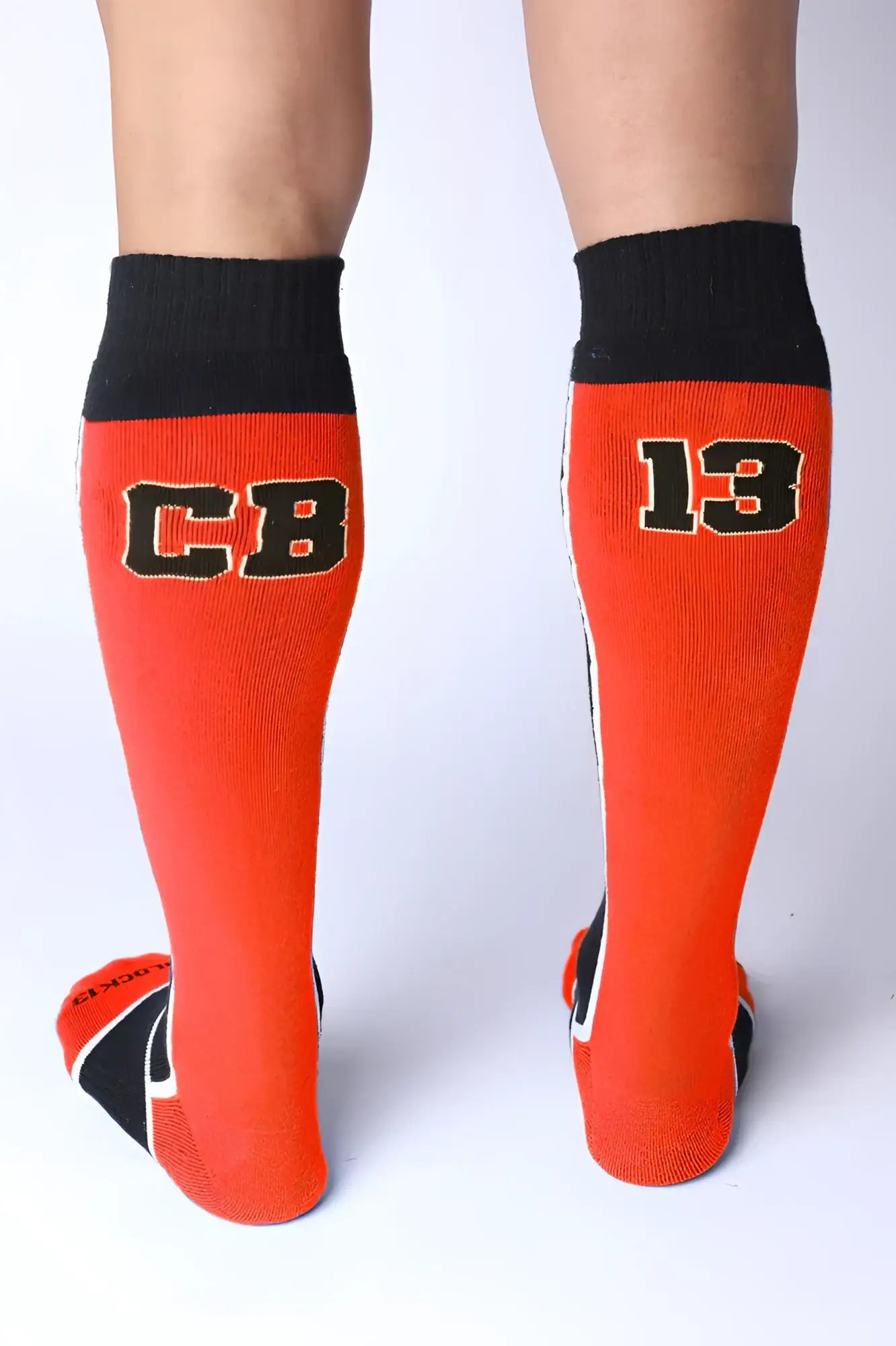 Take down knee high socks in bright orange with black ribbed cuffs toe accents and bold cb 13 lettering outlined in white
