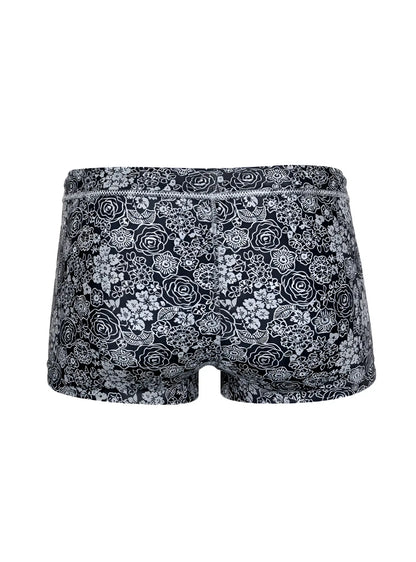 Black briefs tartarus swim trunk with intricate white floral pattern on fabric for swimwear use