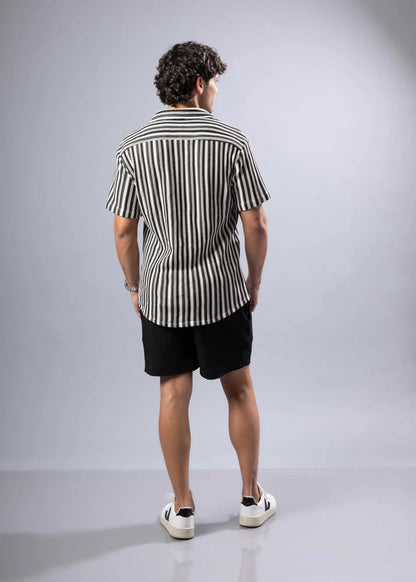 A man wearing a black and white vertically striped texture knit short-sleeved shirt for casual wear
