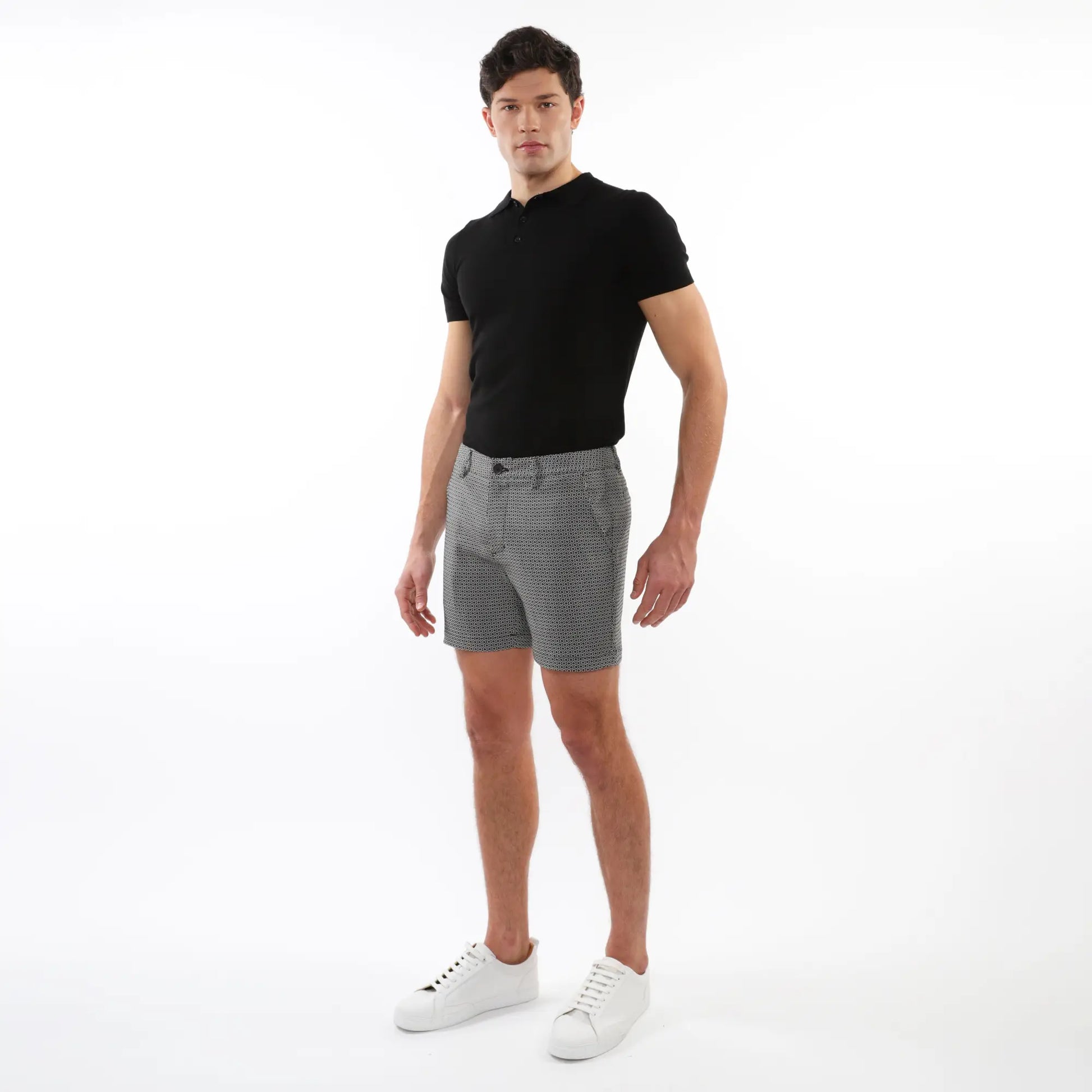 Black short-sleeved polo shirt with classic collar and buttoned placket paired with textured jacquard stretch chino shorts