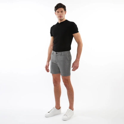 Black short-sleeved polo shirt with classic collar and buttoned placket paired with textured jacquard stretch chino shorts