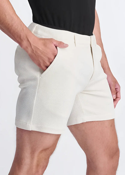 Cream-colored textured stretch knit chino shorts with tailored fit and side pockets for comfortable style