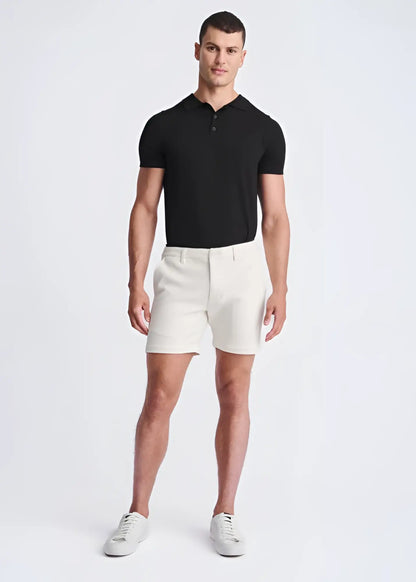 A pair of crisp white textured stretch knit chino shorts with a tailored fit and belt loops