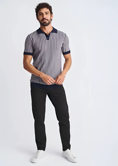 A man wearing a textured stripes silk tencel polo in navy and gray with a dark blue collar and sleeve cuffs