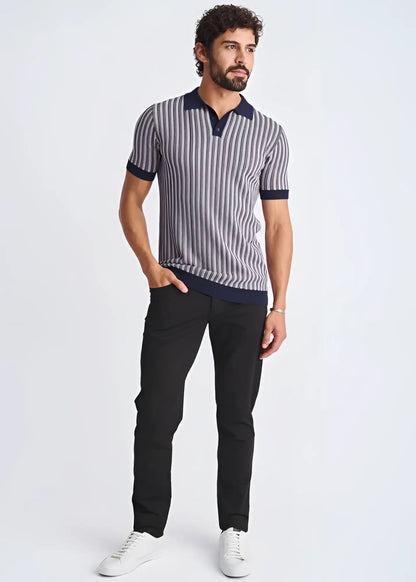 A man wearing a textured stripes silk tencel polo in navy and gray with dark blue collar cuffs and hem