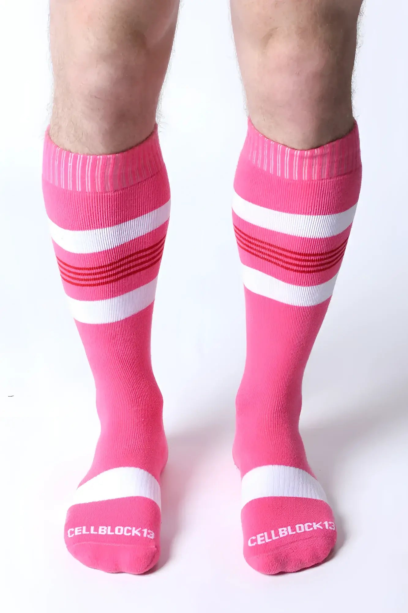 Bright pink tight end knee high socks with white and red stripes featuring cellblock13 logo on the toe
