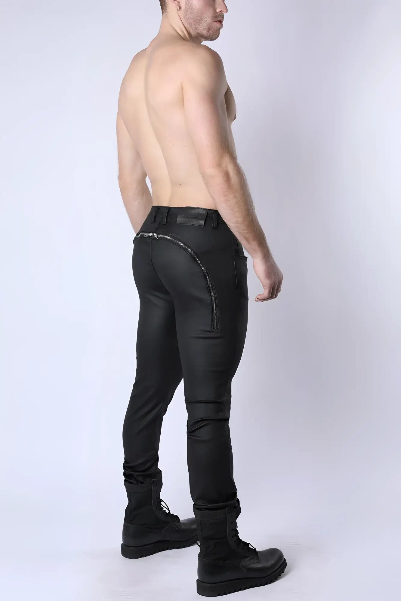 Black leather toro zipper pants with sleek form fitting design and silver zipper along the back seam shown from back side