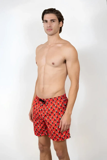 Red swim trunks with a black and white toucan print pattern perfect for beach and pool use