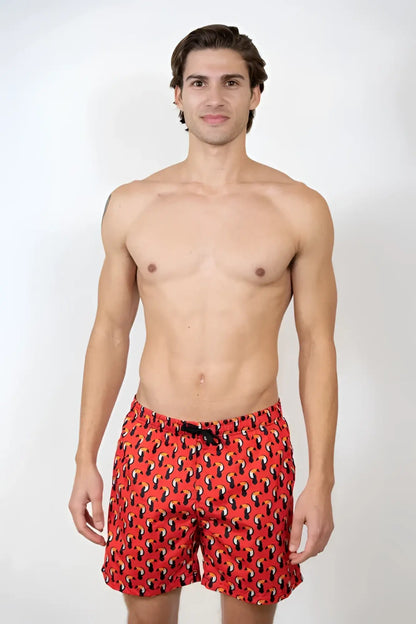 Toucan print swim short featuring red swim trunks with a black and yellow abstract pattern for beachwear